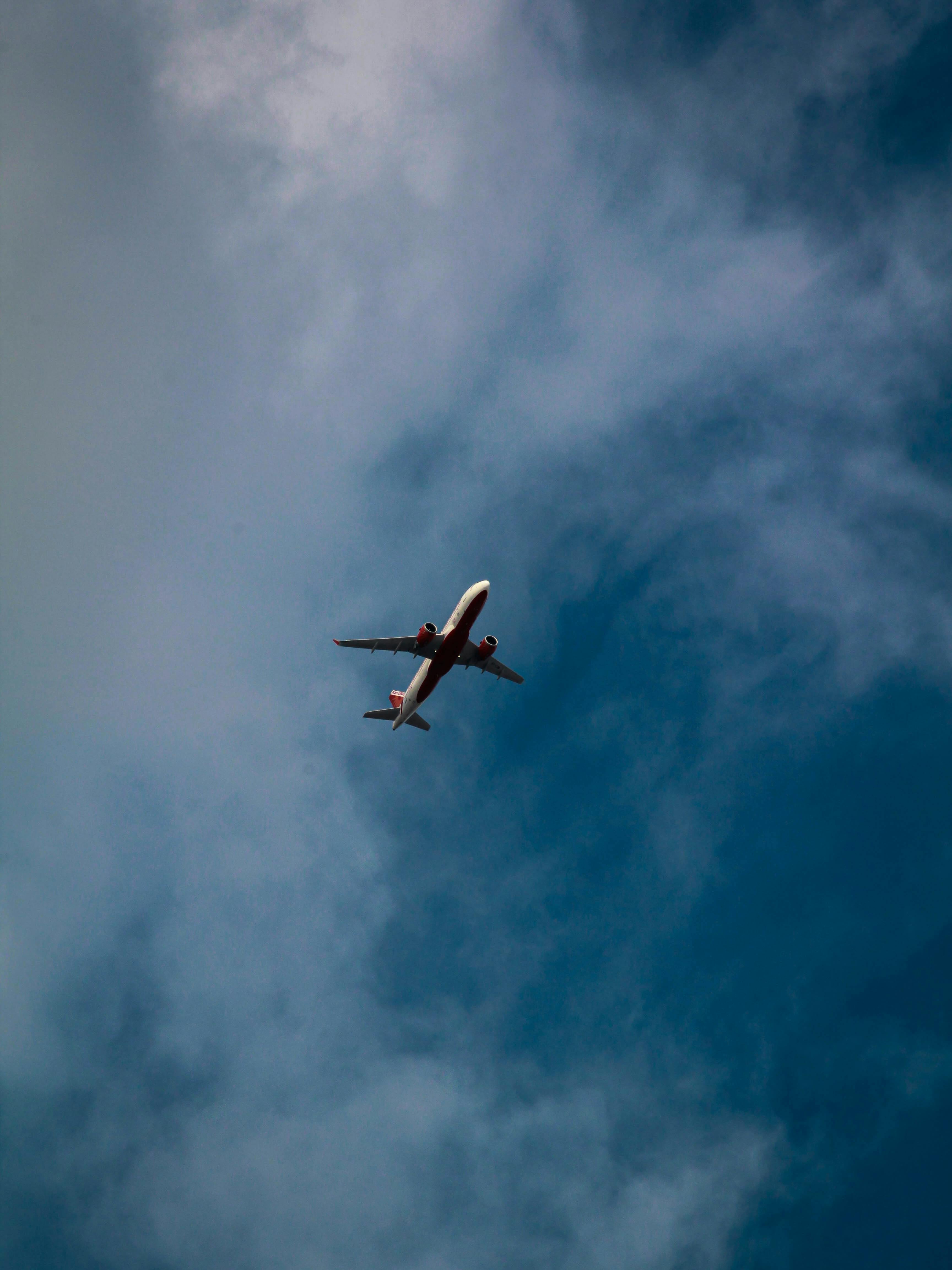 Low Angle Photo of Airplane Flying Under Sky · Free Stock Photo