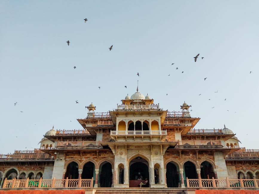 Front view of the iconic Albert Hall Museum in Jaipur with birds flying in the sky.