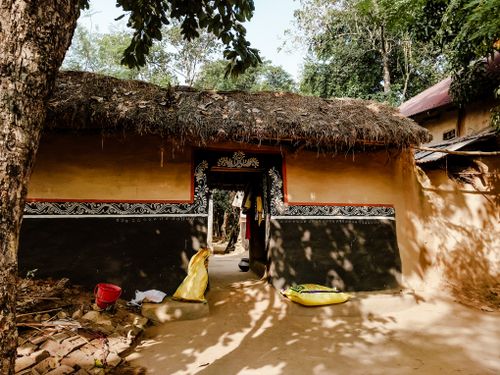 Free Traditional mud house with tribal art and thatched roof in Doladanga, India. Stock Photo