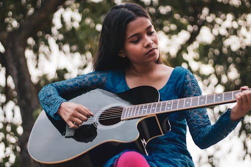 Young Woman Playing on Guitar