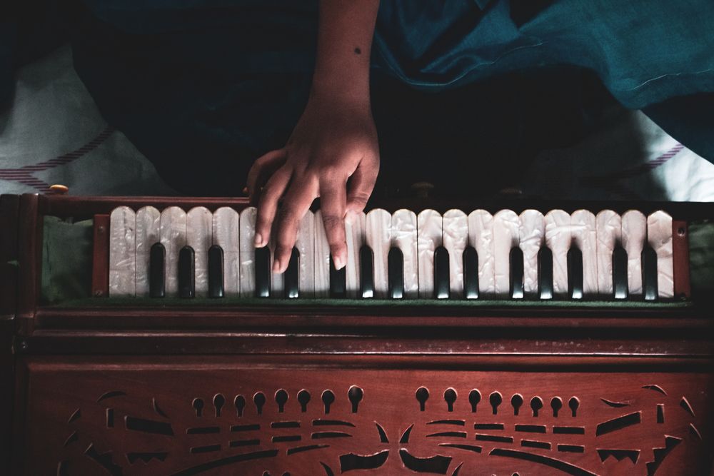 Hand playing a traditional harmonium, used in Gurmat Sangeet and kirtan