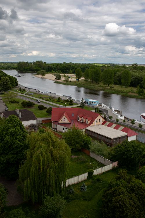 Free Scenic aerial view of houses along a peaceful river in Pinsk, surrounded by lush greenery. Stock Photo