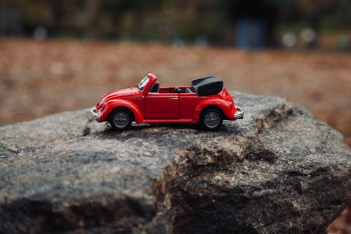 A Red Toy Car on the Rock