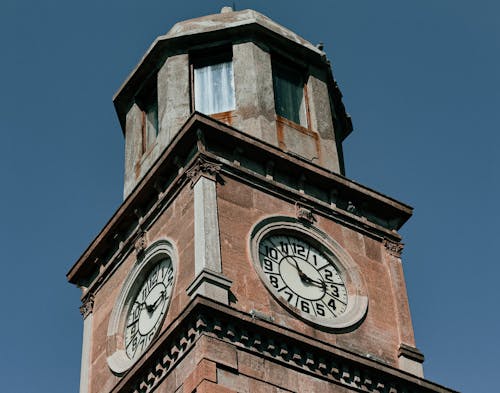 A Low Angle Shot of a Clock Tower Under the Blue Sky