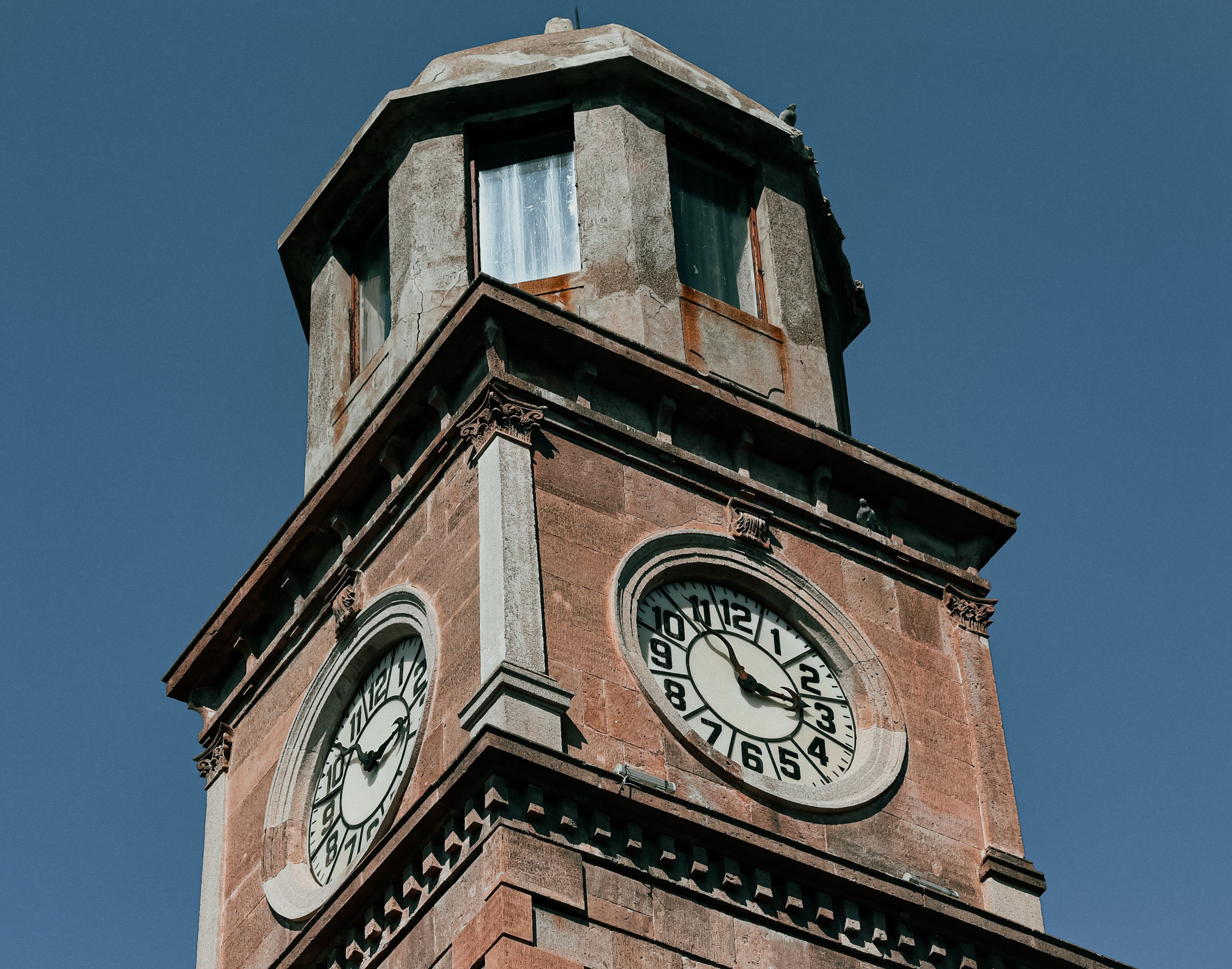 A Low Angle Shot of a Clock Tower Under the Blue Sky · Free Stock Photo