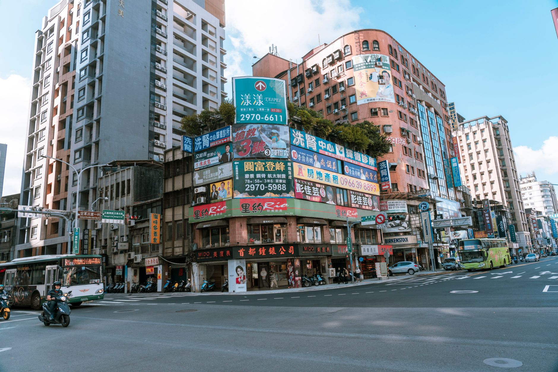 Vibrant street view in Taipei showcasing busy traffic, tall buildings, and colorful signage.