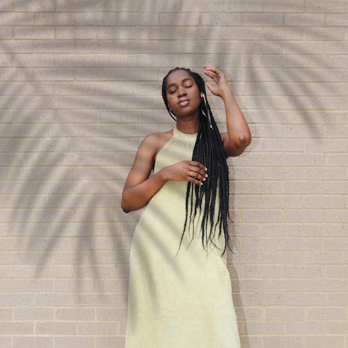 Woman Standing Beside Beige Wall