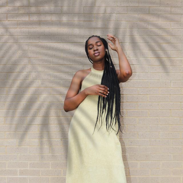 Portrait against a sunlit wall with palm shadows — photo by Ogo Johnson on Pexels