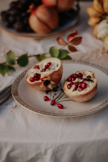 Beautiful still life of pomegranate on vintage plate, showcasing its rich seeds and natural elegance.