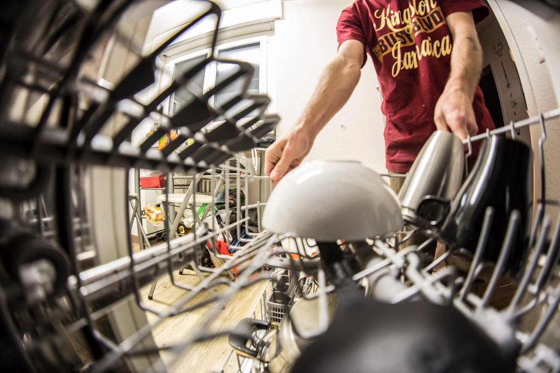 Fish-eye Photography of Man Pulling the Dishwasher Rack