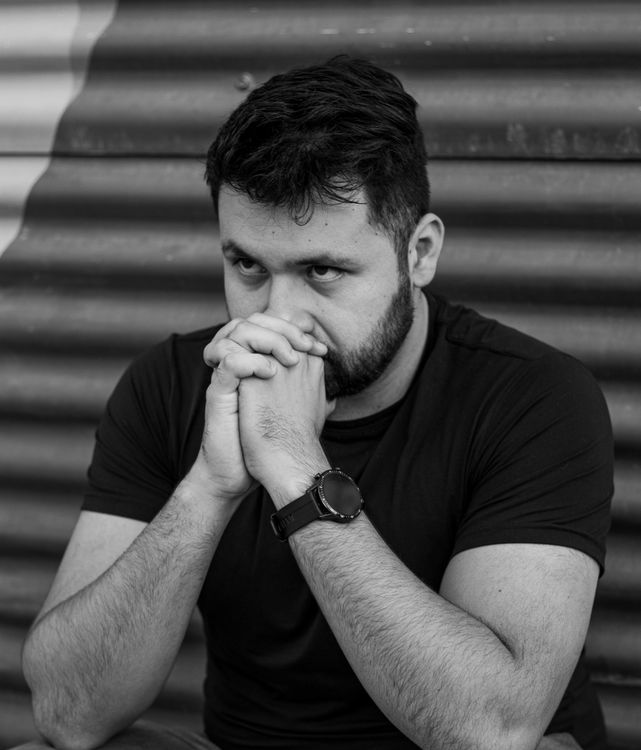 A Grayscale Photo of a Bearded Man in Black Shirt with His Hands ...