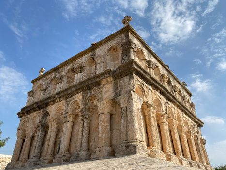 Low angle view of the ancient Roman church facade in Mardin, Türkiye against a blue sky.