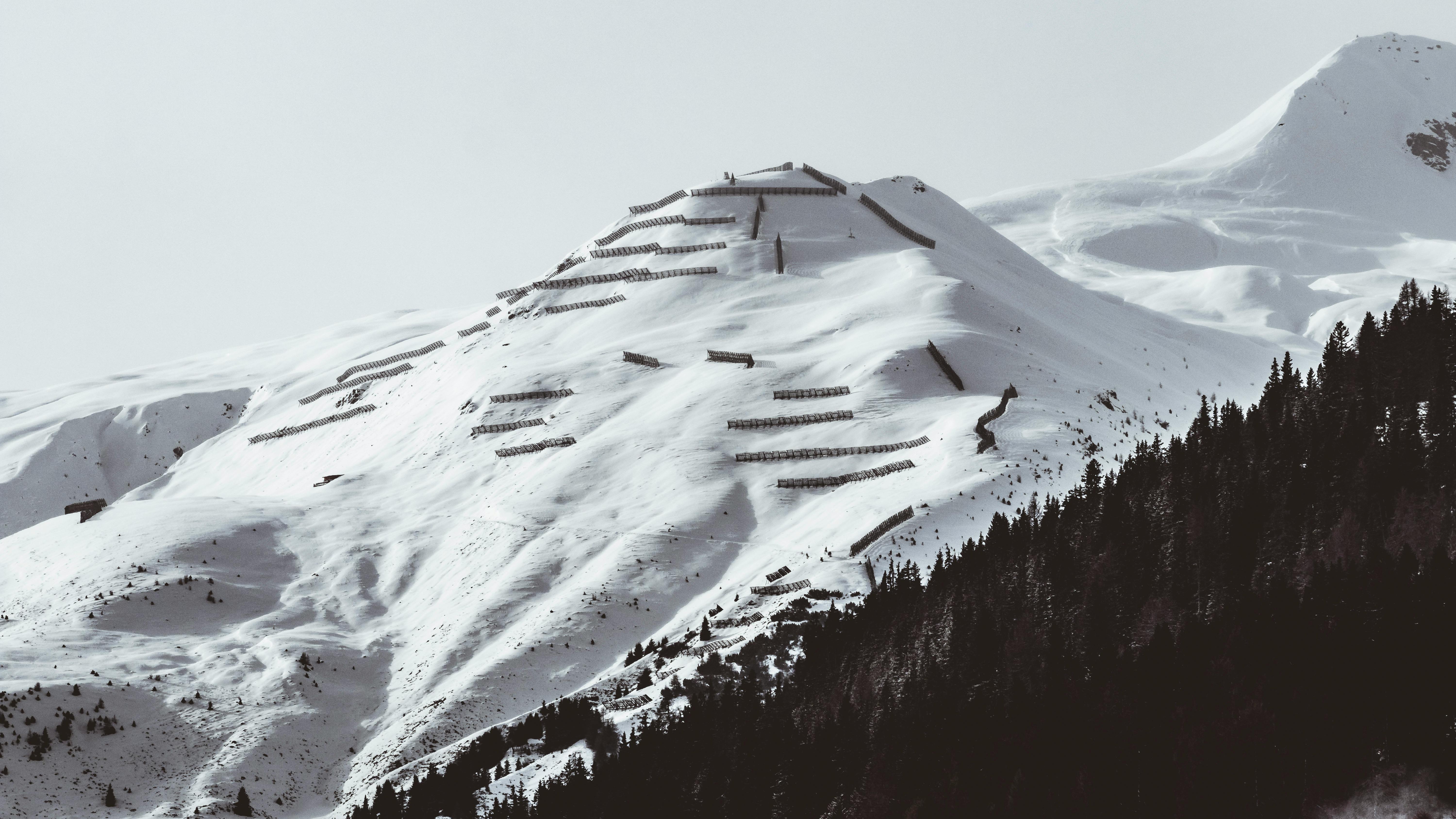 Prescription Goggle Inserts - A tranquil snowy mountain landscape with forest and ski barriers on a winter day.