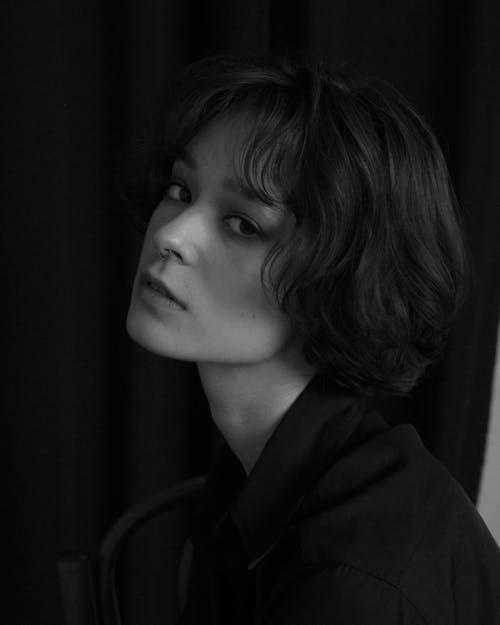 A Grayscale Photo of a Woman in Black Shirt Looking with a Serious Face