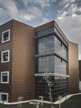Contemporary urban building featuring a sleek glass and wood facade under a cloudy sky.