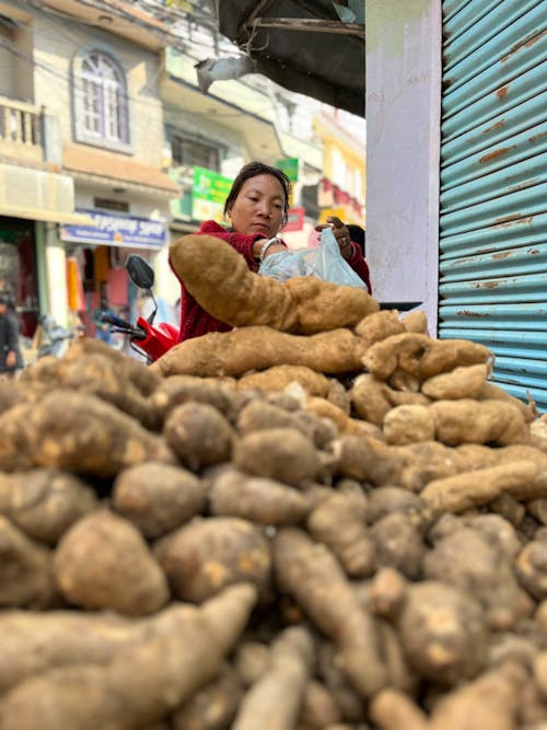 Woman next to a Batch of Root Vegatables