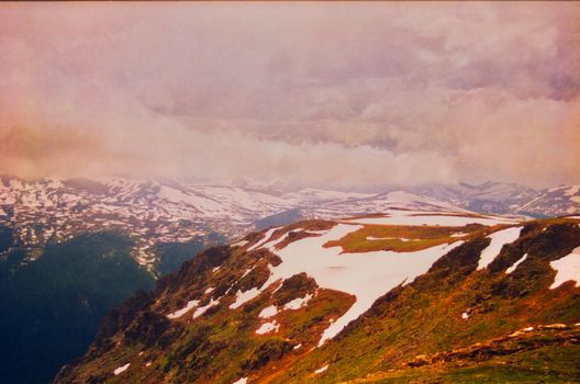 A breathtaking view of a snow-capped mountain range under a cloudy sky, perfect for nature enthusiasts.