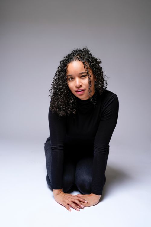 Free Elegant studio portrait of a woman kneeling, showcasing confidence and beauty. Stock Photo