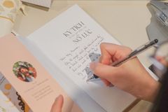 Woman writing a letter in a cozy indoor setting with personal stationery.