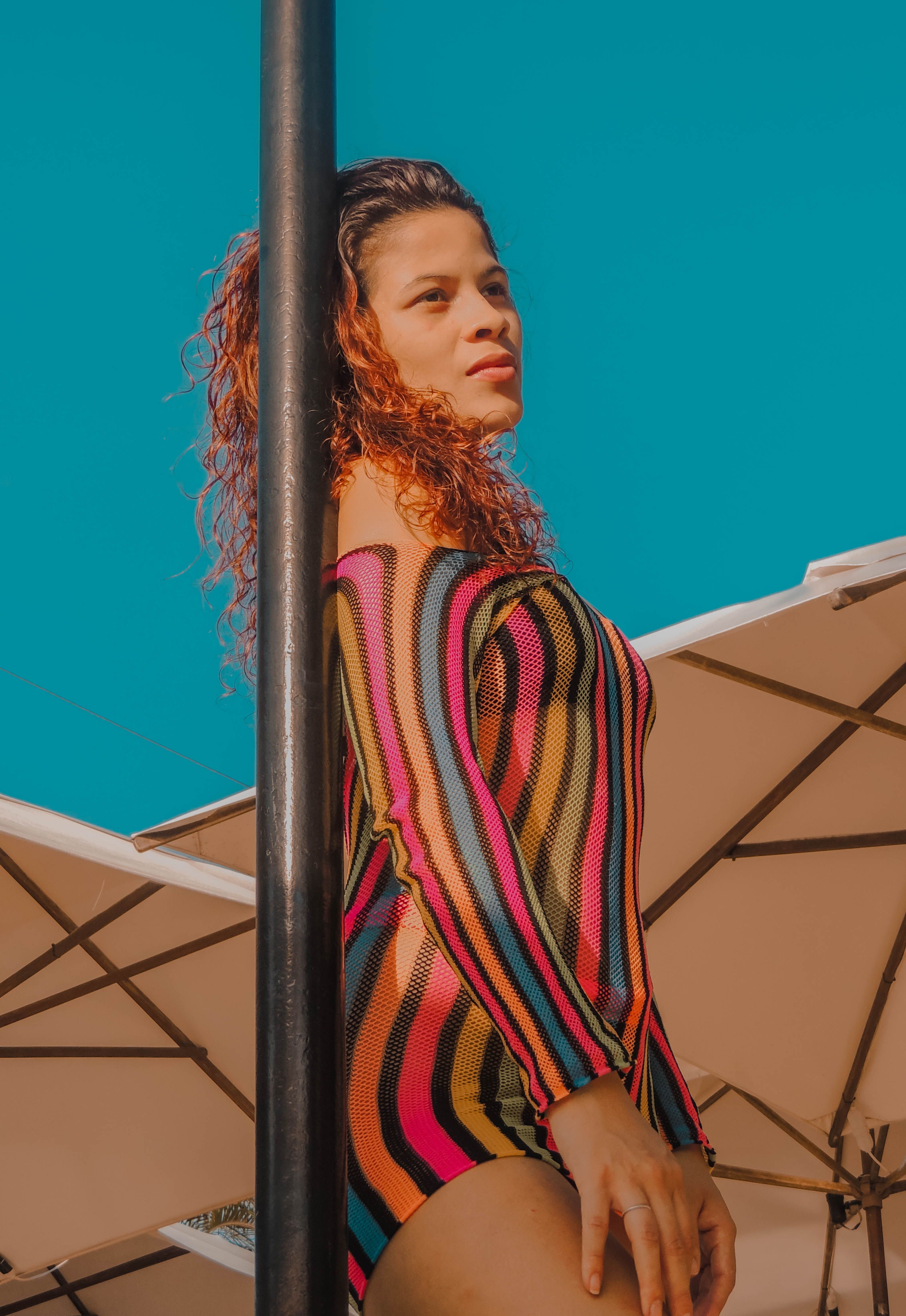 Woman Wearing Stripe Swimwear Leaning on a Pole · Free Stock Photo