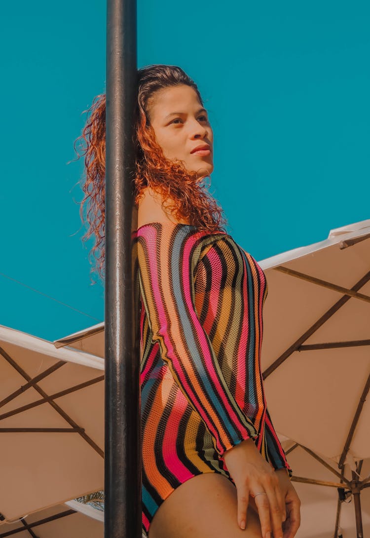 Woman Wearing Stripe Swimwear Leaning On A Pole