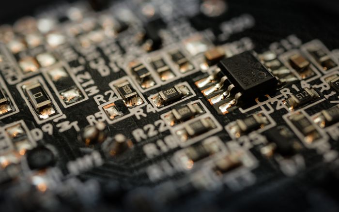 Close-up of a black semiconductor circuit board with electronic components.
