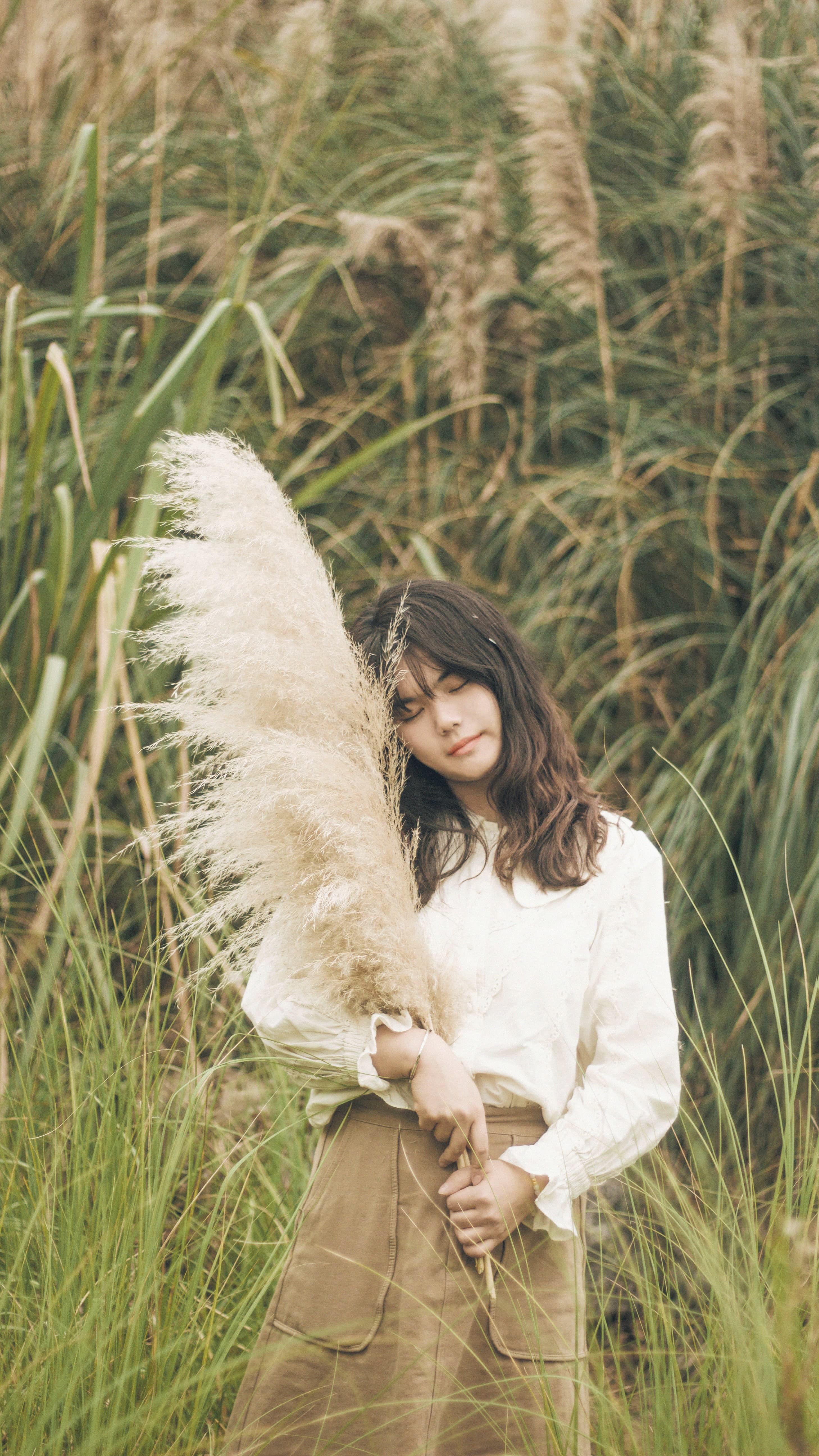 Woman in White Long Sleeve Shirt Standing on Green Grass Field · Free ...