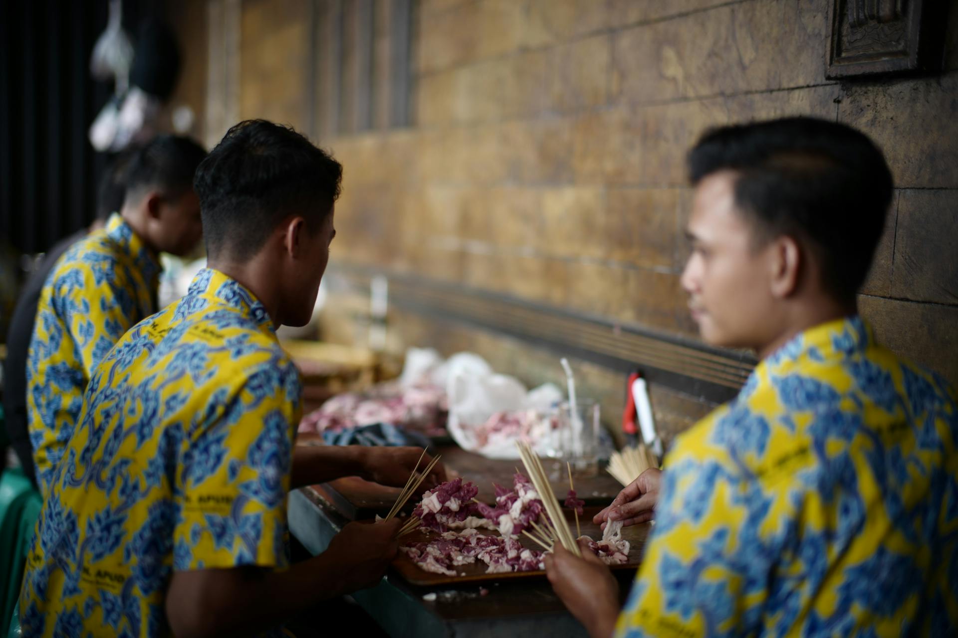 Men Stuffing Chopped Raw Meat Onto Skewers