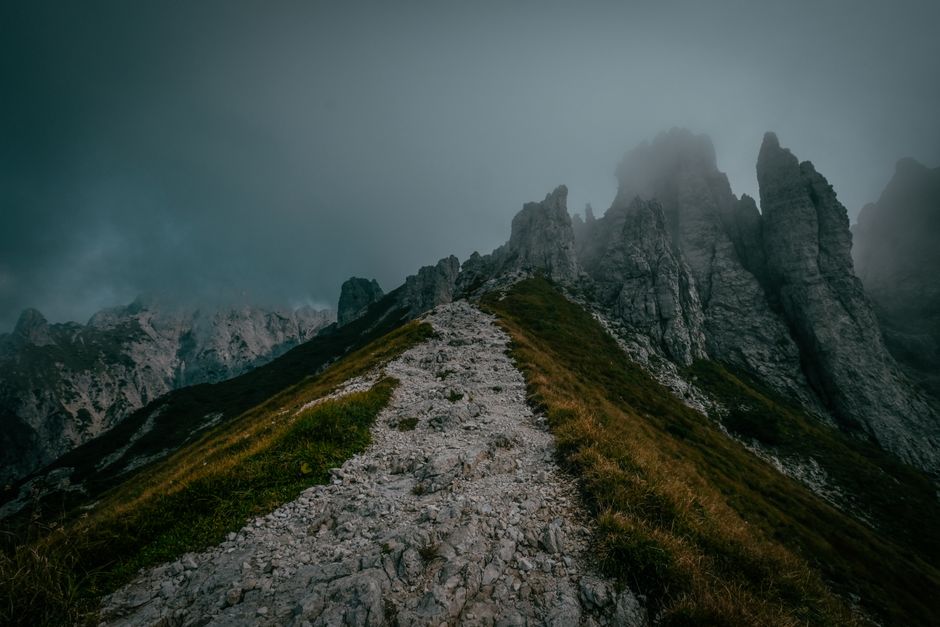 Capture of a misty mountain peak in Mandello del Lario, Italy, showcasing a dramatic, rugged landscape.