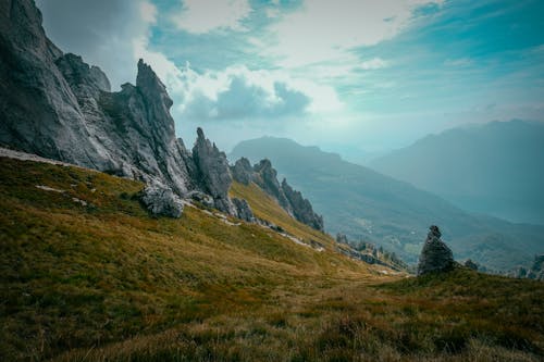 бесплатная Зеленая и черная гора во время белого облачного неба Стоковое фото