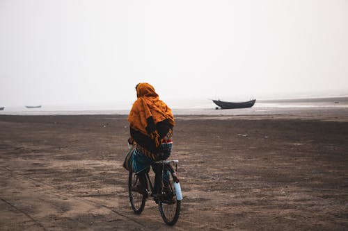 A Person wearing a Scarf While Riding a Bicycle 