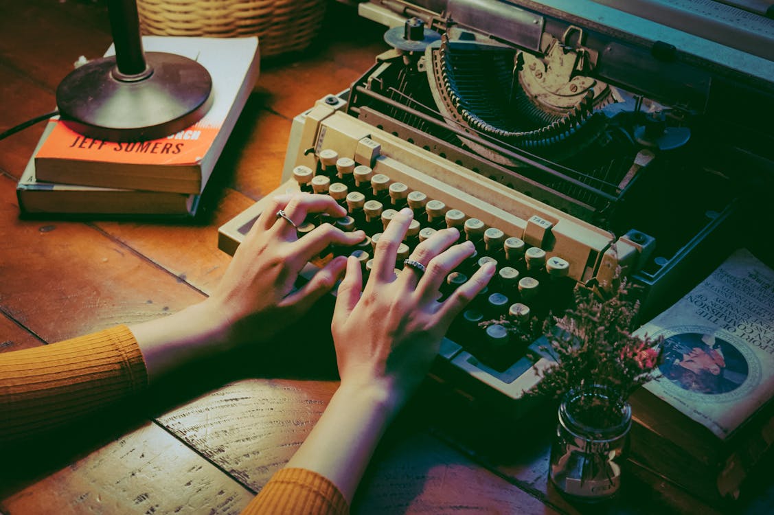 Free Person Using Typewriter representing the writer type of virtual assistant