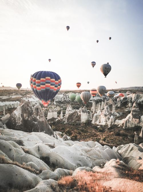 Free Stunning hot air balloons float above unique rock formations in Cappadocia, Turkey at dawn. Stock Photo