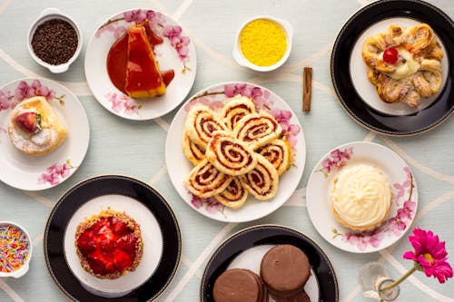 бесплатная Разнообразие запеченных и десертных блюд на тарелках Стоковое фото