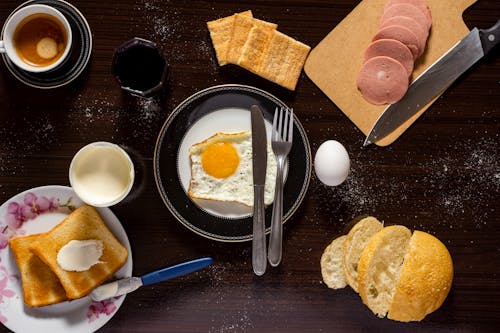 Free Plate of Sunny Side-up, Sliced Meat, and Bread Stock Photo