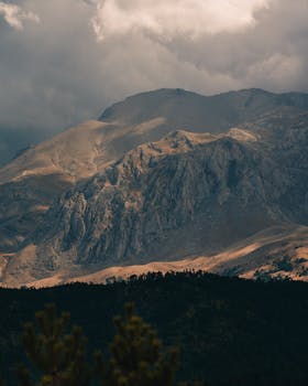 Moody mountain range under dark clouds at twilight, enhancing the dramatic scene.