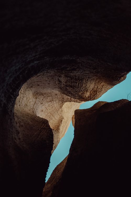 Free Stunning view of rugged rock formations inside a cave under a clear blue sky. Stock Photo