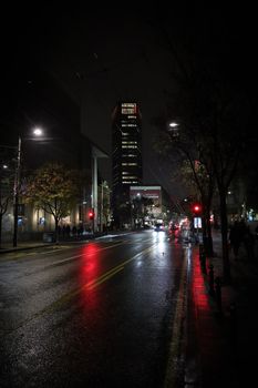 Atmospheric street view of Belgrade at night with wet roads and city lights.