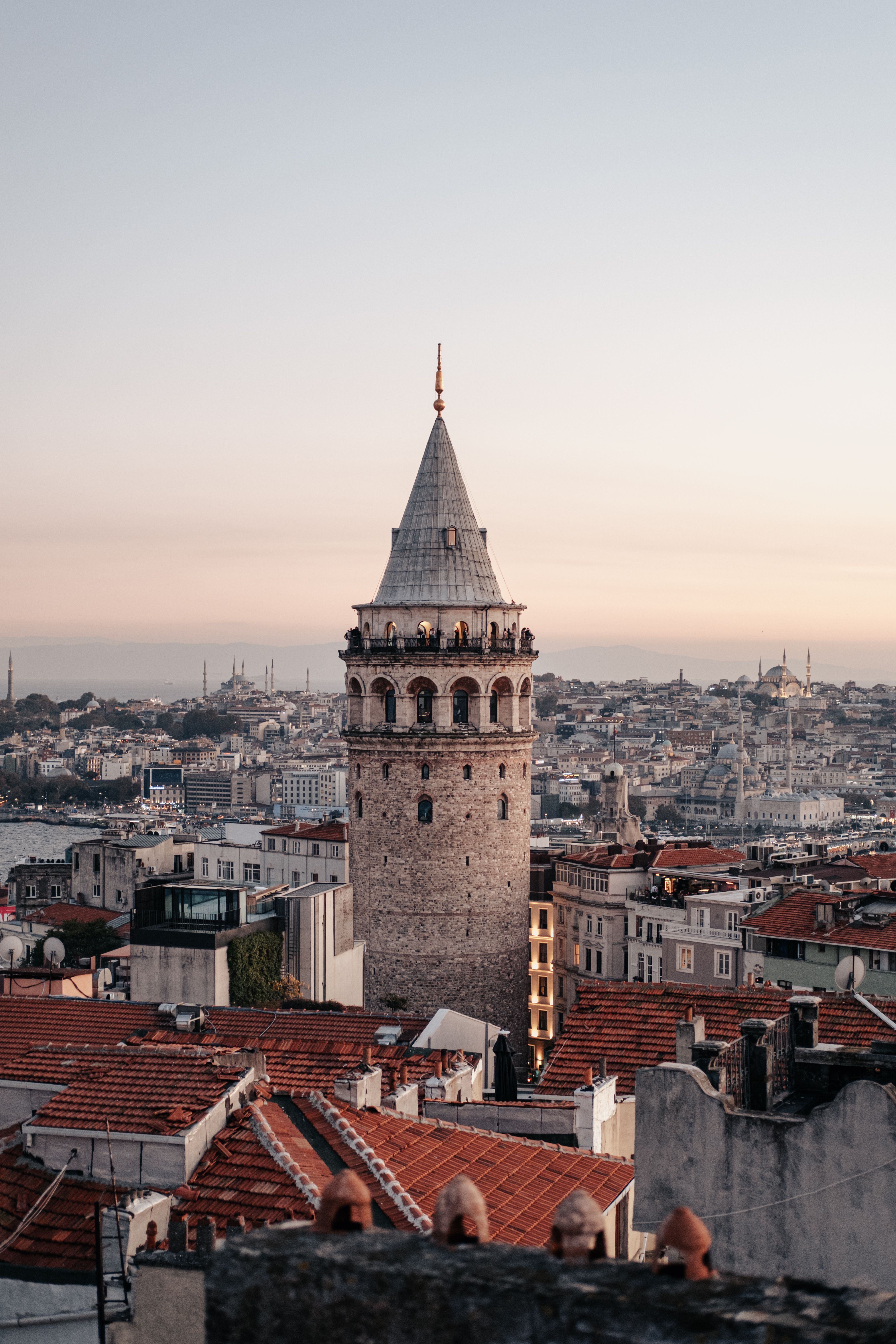 Historic Galata Tower amidst Istanbul's skyline during sunset, capturing architectural beauty.