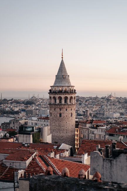 Historic Galata Tower amidst Istanbul's skyline during sunset, capturing architectural beauty.