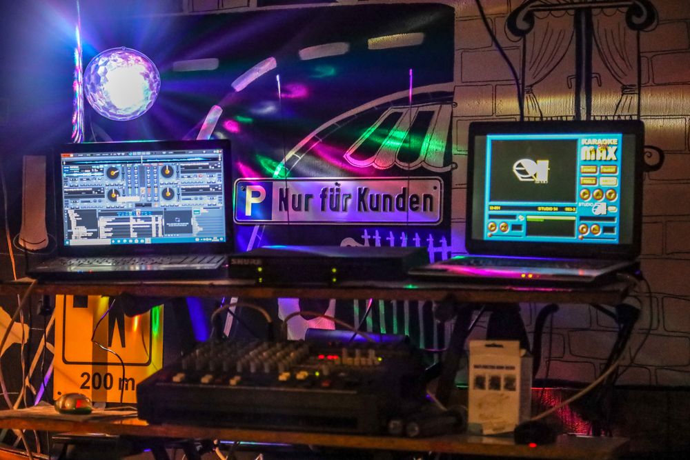 Een dj-booth in een club met mixer en schermen