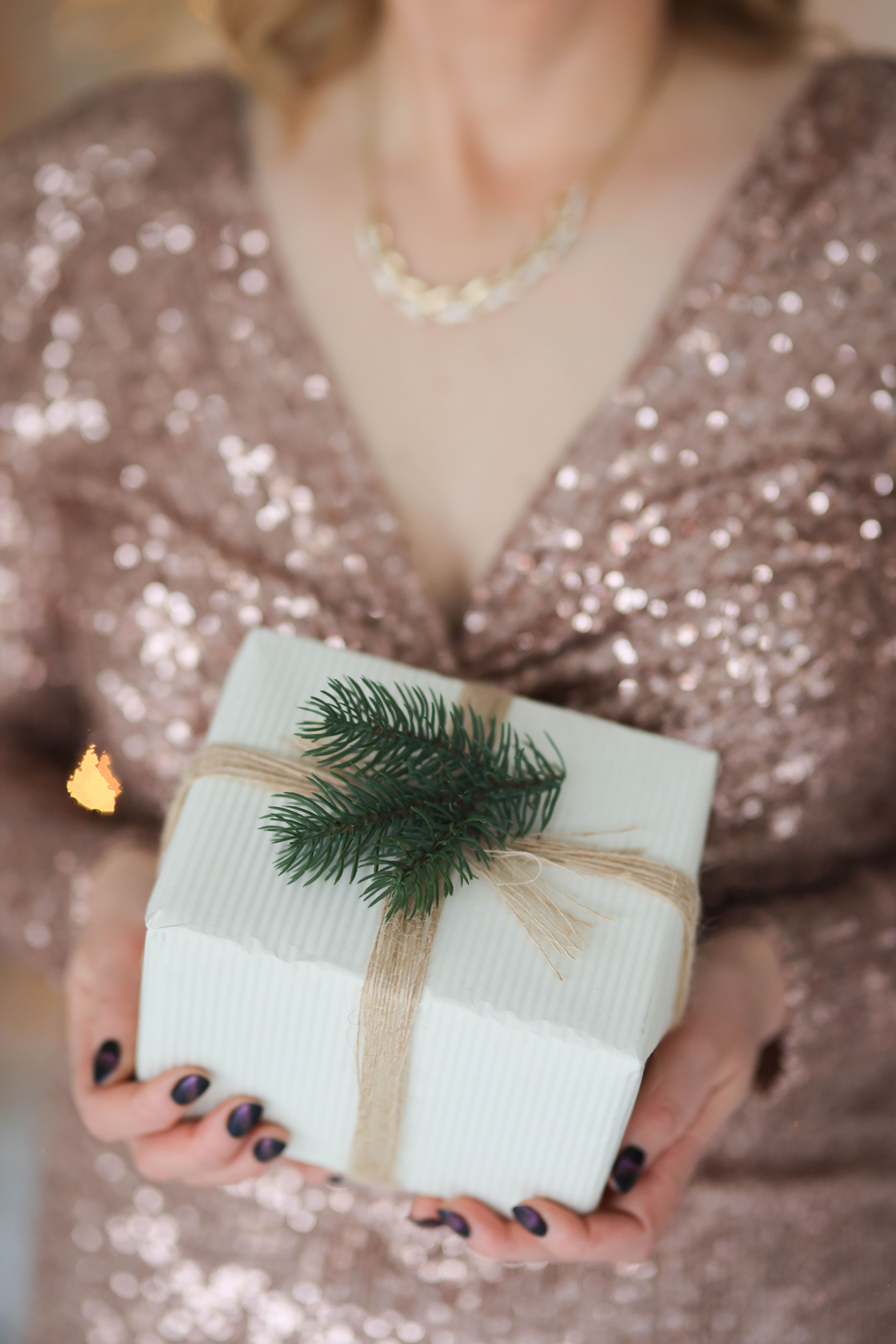 Plus size sequin dress holiday party look with sparkling sequin outfit and festive wrapped gift