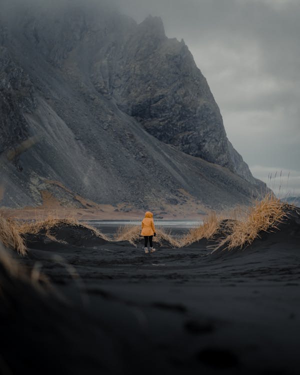 Person in Yellow Jacket on Black Soil