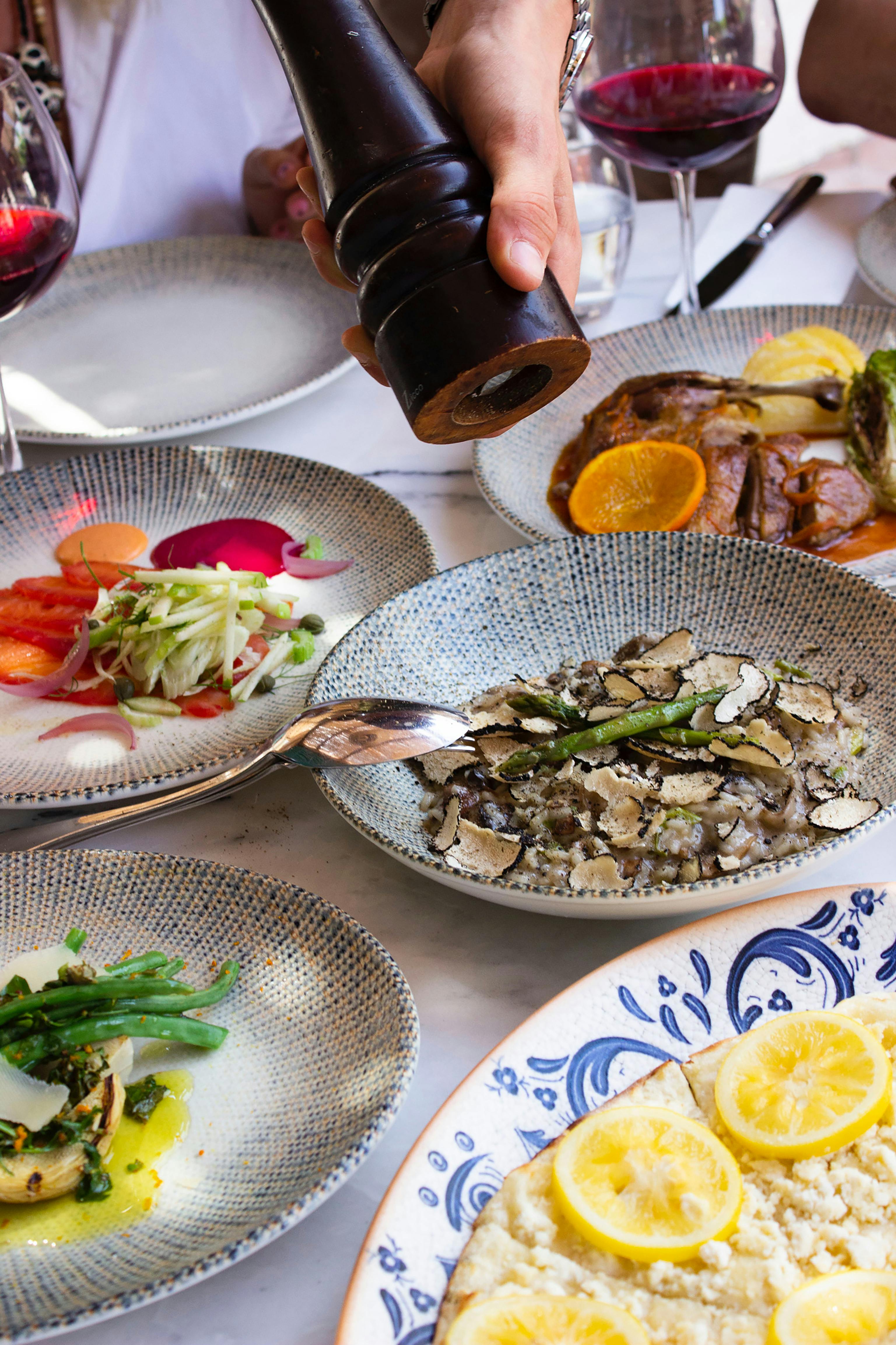 a table with plates of food and a bottle of wine