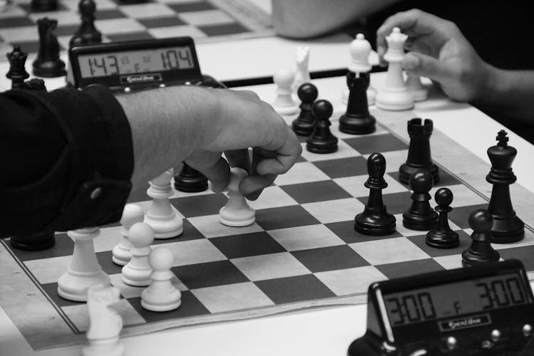 Person Playing Chess Game On Chess Board