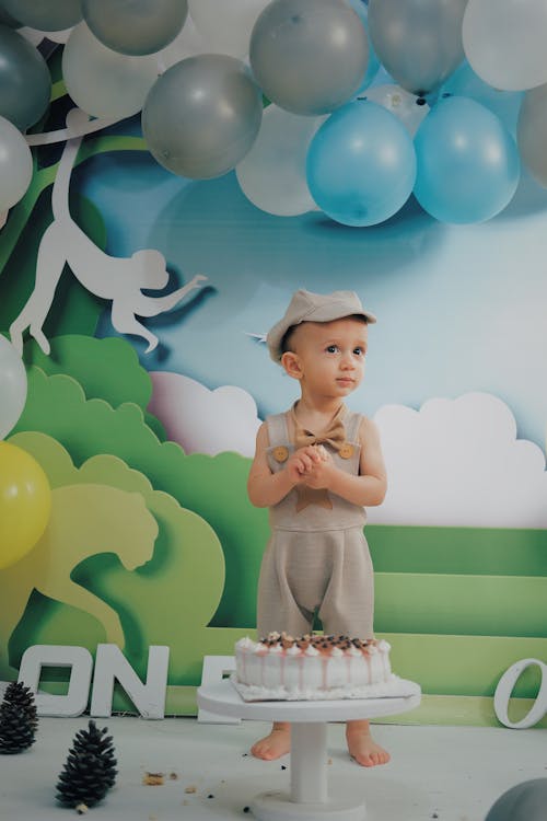Boy Standing Behind a Cake