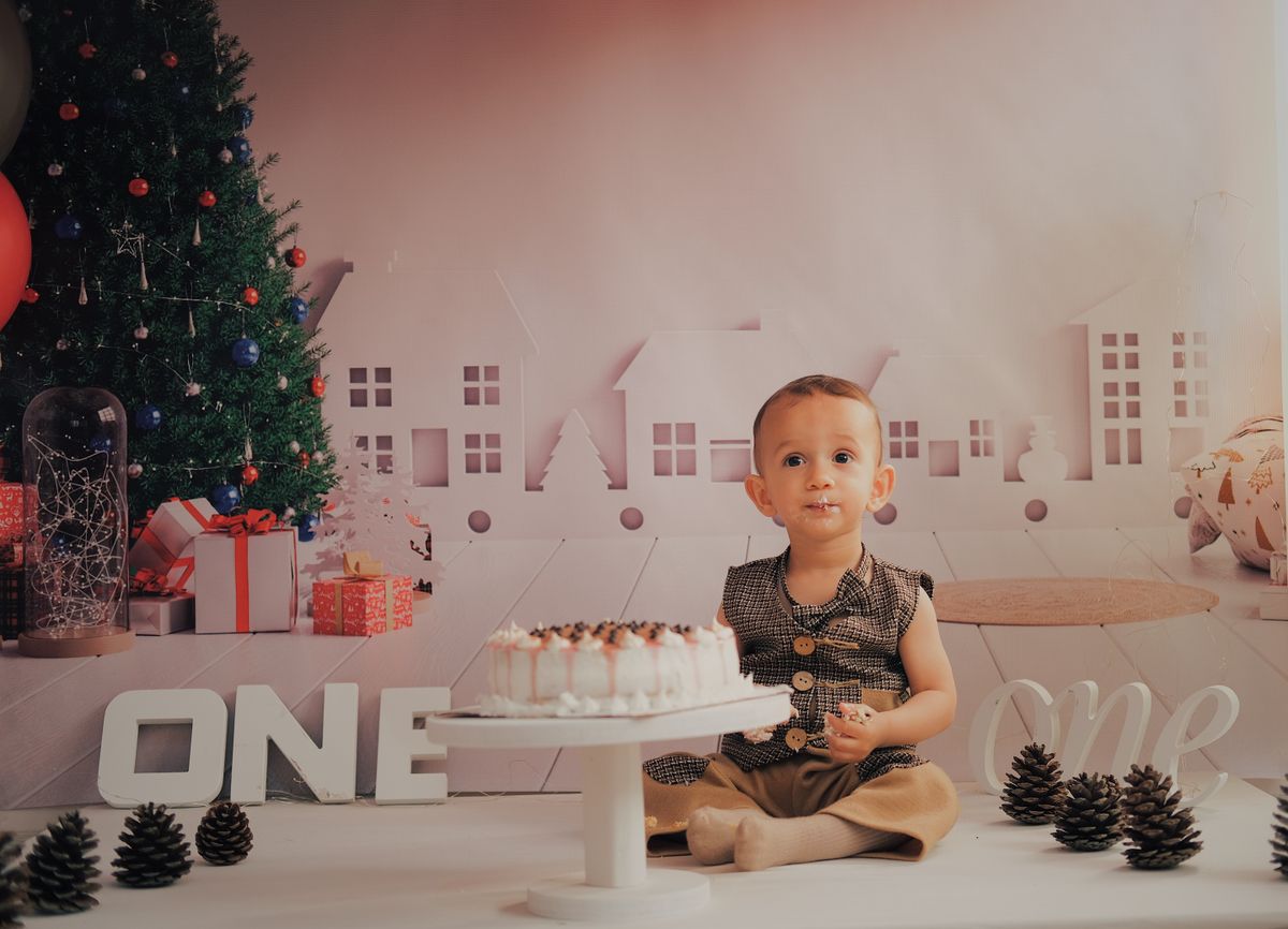 Cute child celebrating first birthday with cake and festive decor indoors. Stock Photo.