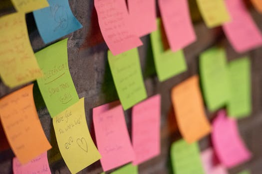 Close-up of colorful sticky notes on a wall, conveying messages and reminders.