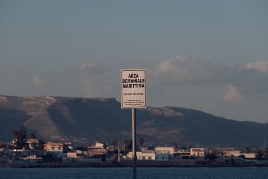 Maritime area sign at Calabernardo's coastline, framed by Sicilian hills and seascape.