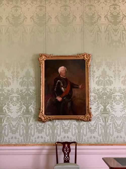 Free Luxurious baroque room featuring an ornate portrait frame and classic wooden chair. Stock Photo